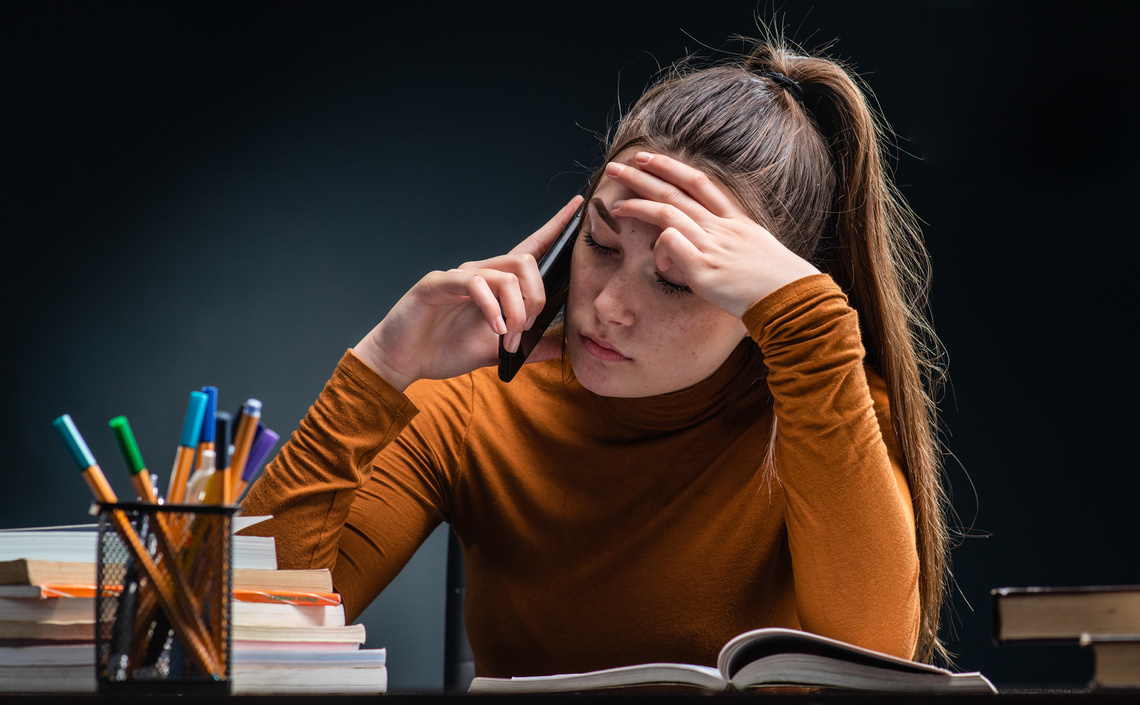 Young beauty but stressed student girl studying for hard exam